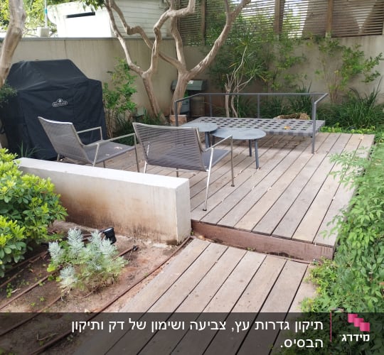דק עץ עם כיסאות ושולחן מתכת בגינה